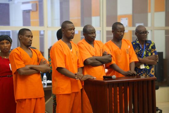 Ndélé 1 trial before the Special Criminal Court in the Central African Republic: the 4 defendants line up at the bar in orange prison garb.