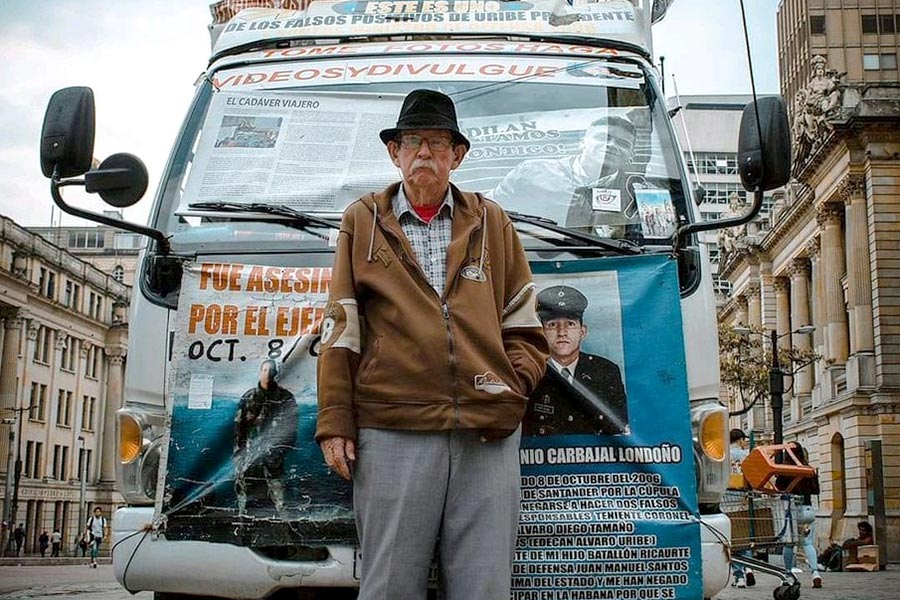 Raúl Carvajal en Bogotá delante de su furgoneta, transformada en museo ambulante, exigiendo justicia para su hijo Raúl Antonio, cabo del ejército asesinado por negarse a participar en los «falsos positivos».