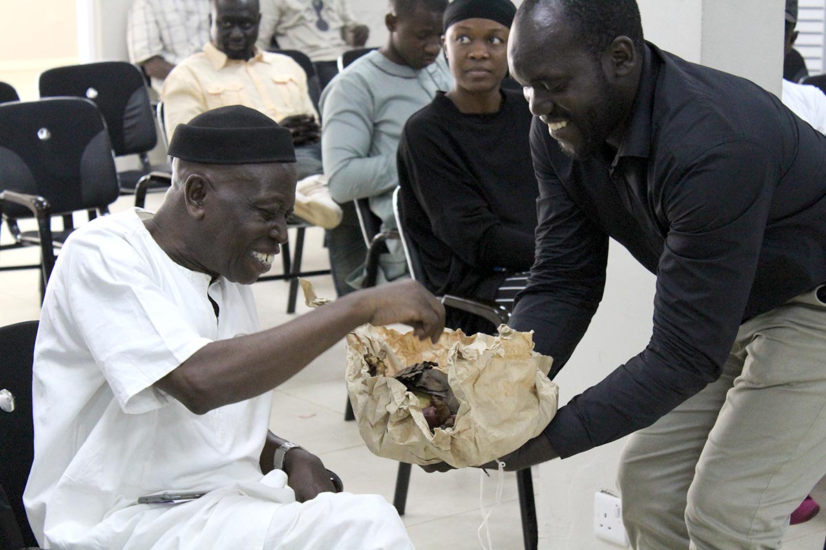 2 gambians share cola nuts as a sign of reconciliation