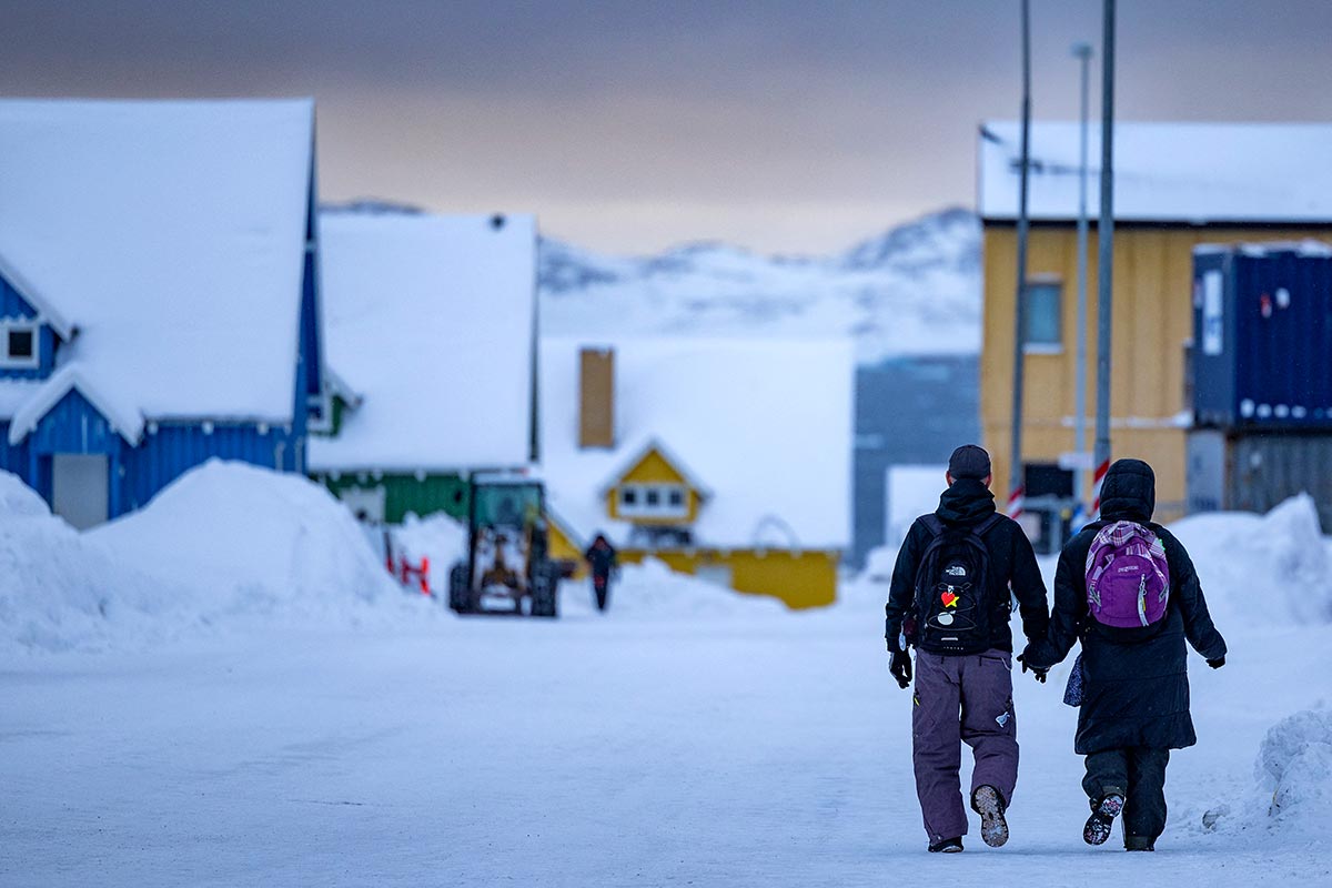 Our world tour of countries that position themselves as invaders (perpetrators of annexations). Photo: A couple walk backwards along a snow-covered street in Nuuk.