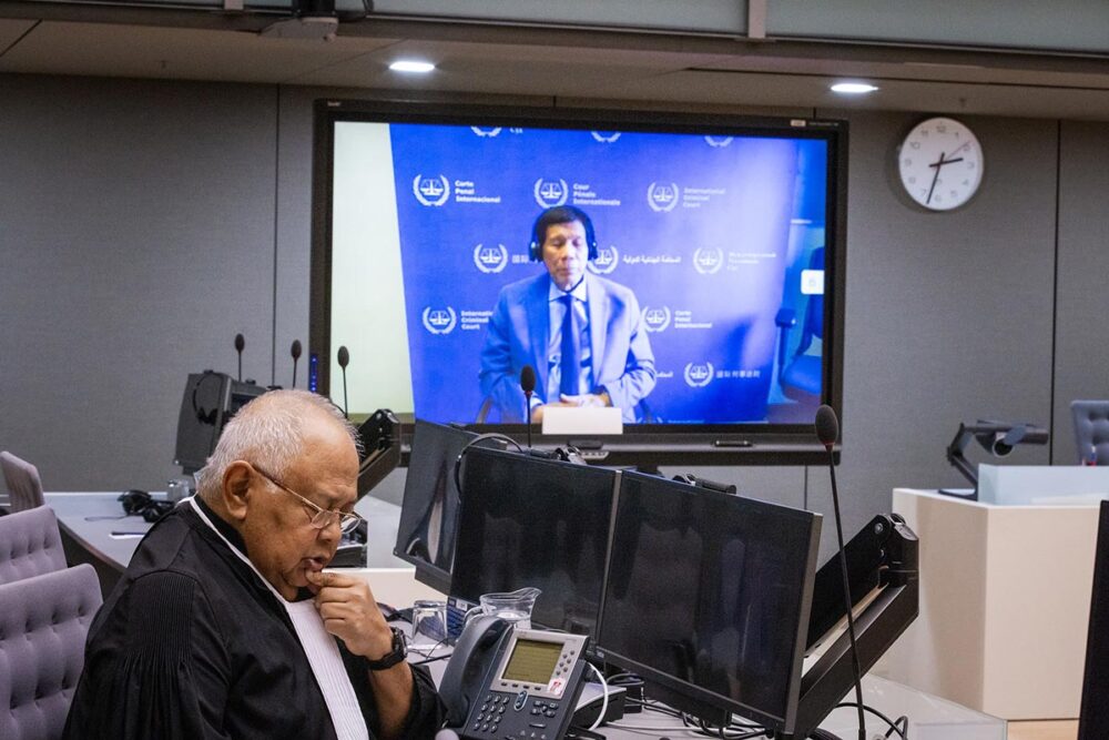 L'ex-président des Philippines, Rodrigo Duterte, comparaît devant la Cour pénale internationale (CPI) en visioconférence. Photo : au premier plan, l'avocat de Duterte, en arrière-plan, Duterte lui-même projeté sur un écran vidéo.