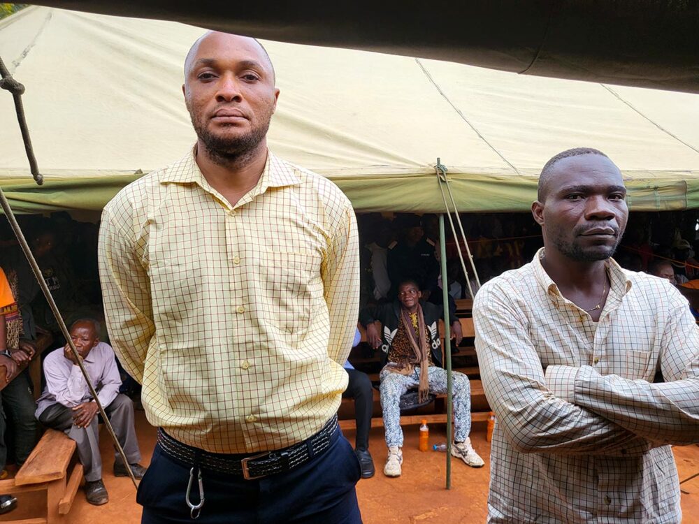 Dans la région du Kasaï, en République démocratique du Congo, le verdict se confirme en appel pour deux accusés, ex miliciens Kamuina Nsapu, lors d'un procès pour crimes de guerre. Photo : les deux accusés posent sous une tente installée à l'occasion d'une audience foraine dans un village ont eu lieu les crimes.