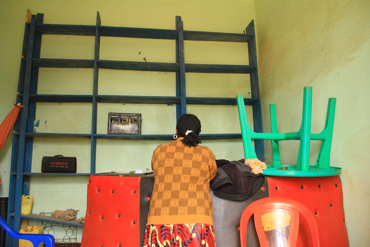 In the Democratic Republic of Congo, a victim of Lubanga's militia had to convert her former store into a dormitory. It had been financed with ICC aid. Photo: a woman seen from behind in a shop.