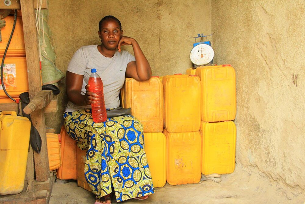 Victime des milices en 2003 en République démocratique du Congo, Ruth Biangire, a pu profiter de l'aide la Cour pénale internationale (CPI). Photo : Ruth Biangire pose dans sa boutique, où elle vend de l'essence en bidons et en bouteilles.