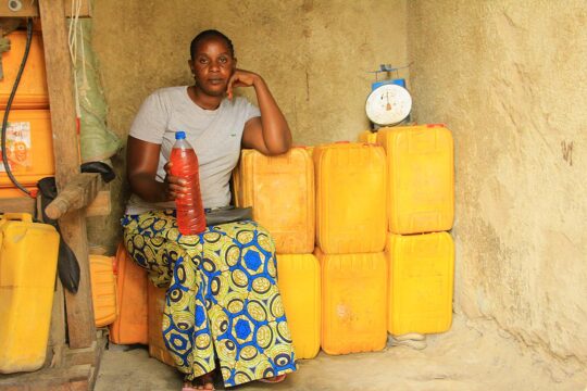 Victime des milices en 2003 en République démocratique du Congo, Ruth Biangire, a pu profiter de l'aide la Cour pénale internationale (CPI). Photo : Ruth Biangire pose dans sa boutique, où elle vend de l'essence en bidons et en bouteilles.