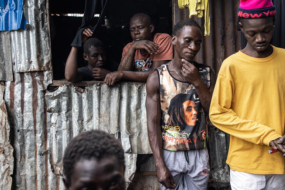 Consommateurs autour d'un lieu de deal de 'kush' à Freetown. Le kush, un mélange de  produits chimiques et de plantes qui imitent les propriétés du cannabis, est de plus en plus consommé par les jeunes en Sierra Leone.