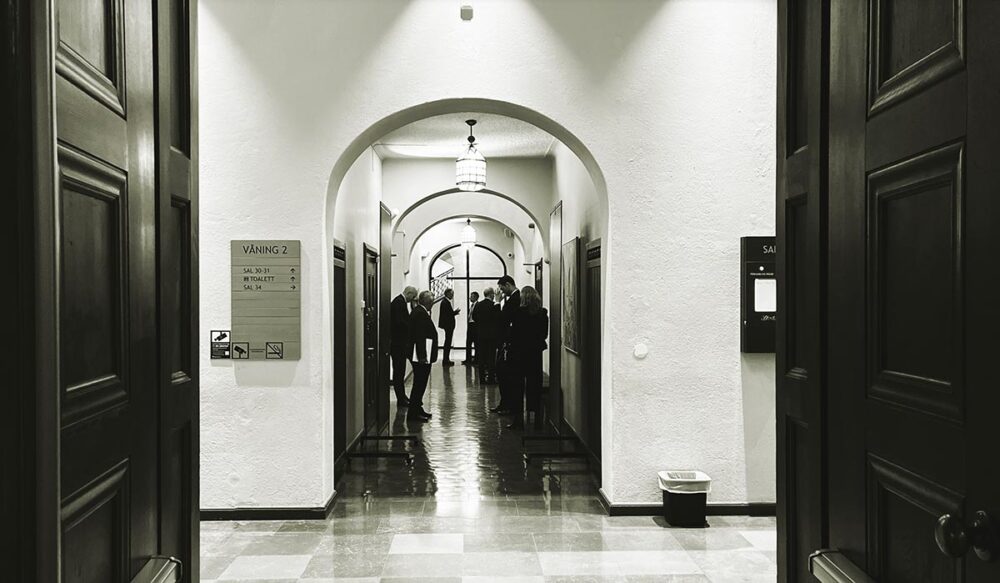 Procès Lundin en Suède - Photo : les accusés et leur équipe de défense patientent dans un couloir du tribunal, près de la salle d'audience numéro 34.