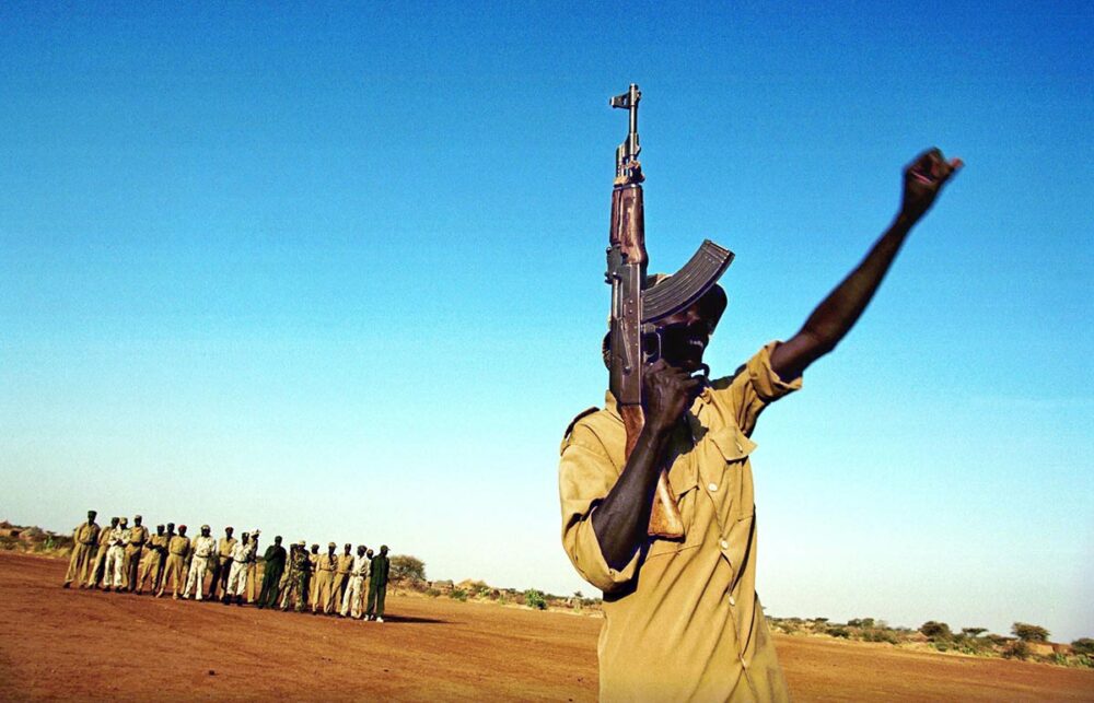 Procès Lundin en Suède - Photo : des soldats de l’Armée populaire de libération du Soudan (SPLA) s’entraînent. Un homme brandit une arme et le poing.