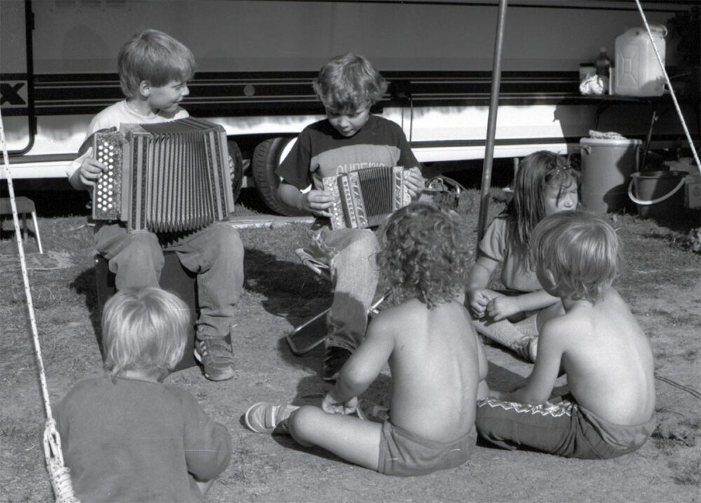 In Switzerland, crimes committed against nomadic peoples (Yenish, Sinti and Manouche) have been recognised by the government as ‘crimes against humanity’. Photo: Yenish children play the schwyzerörgeli, a small accordion, in front of a vehicle parked in an encampment.