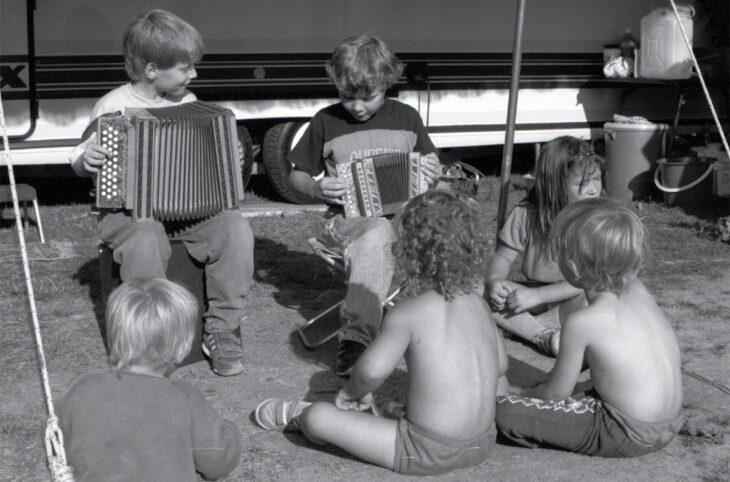 In Switzerland, crimes committed against nomadic peoples (Yenish, Sinti and Manouche) have been recognised by the government as ‘crimes against humanity’. Photo: Yenish children play the schwyzerörgeli, a small accordion, in front of a vehicle parked in an encampment.