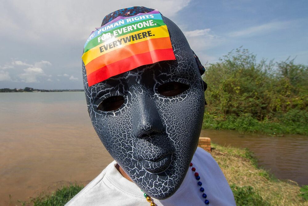 Persecution of LGBTQ people: a crime against humanity? Photo: in Uganda, a gay activist wears a mask on which he has stuck a rainbow flag.