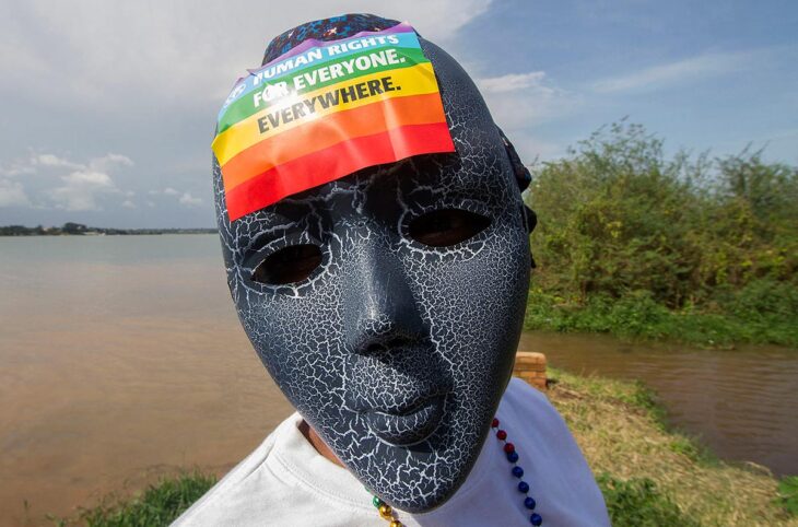 Persécution des LGBTQ : un crime contre l'humanité ? Photo : en Ouganda, un activiste gay porte un masque sur lequel il a collé un drapeau arc-en-ciel.