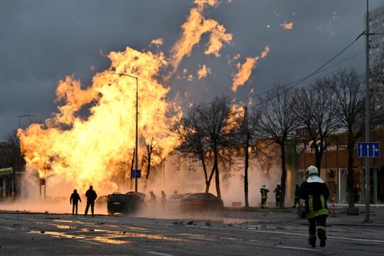 Guerre illégale - Photo : A Kiev (Ukraine) des civils observent l'incendie créé par une explosion, suite à une frappe de missile russe.