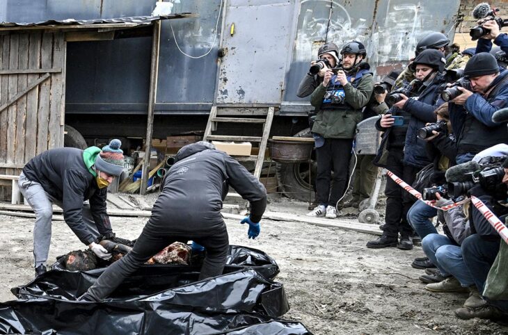 In a street in Boutcha, Ukraine, journalists filmed and photographed burnt corpses being handled by people to move them.