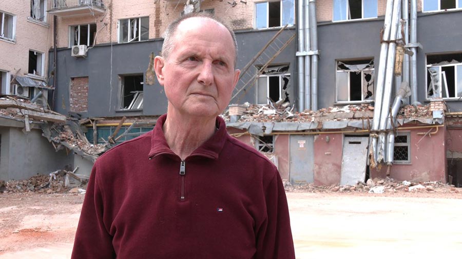 Mykola Tarasovets devant l'Hôtel Ukraine détruit à Tchernihiv.