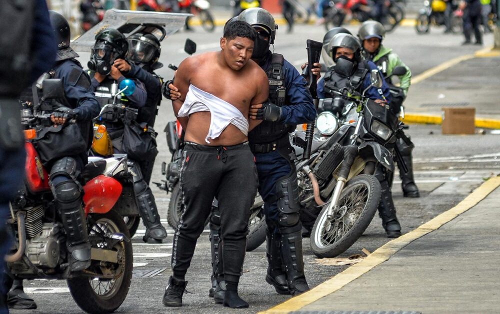 La Cour pénale internationale est-elle suffisamment impliquée pour juger les responsables des répressions policières meurtrières de 2024 lors des manifestations de l’opposition ? Photo : des membres des forces de sécurité (à moto) arrêtent un manifestant dans une rue de Caracas.