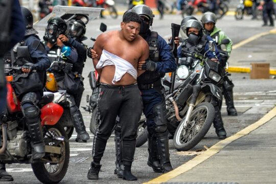 La Cour pénale internationale est-elle suffisamment impliquée pour juger les responsables des répressions policières meurtrières de 2024 lors des manifestations de l’opposition ? Photo : des membres des forces de sécurité (à moto) arrêtent un manifestant dans une rue de Caracas.