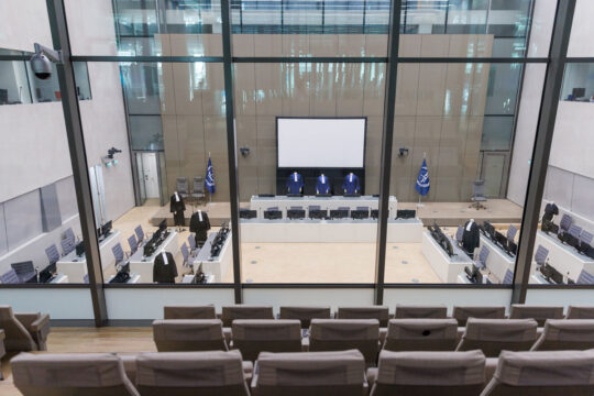 La salle d’audience de la Cour pénale internationale avec des sièges vides.